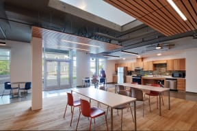 a large dining room with tables and chairs and a kitchen