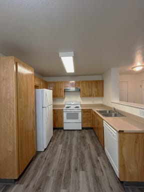 a kitchen with white appliances and wooden cabinets