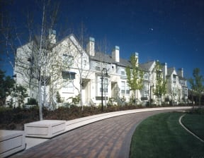 a large white house with a sidewalk in front of it