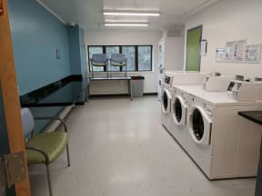 an empty laundry room with washing machines and sinks