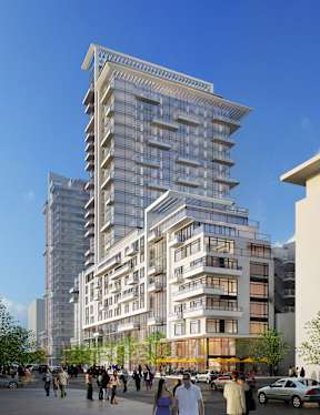 A modern multi-story building with balconies and large windows is surrounded by a crowd of people.
