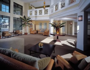 a lobby of a hotel with couches and a table