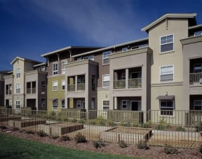an exterior view of an apartment complex with a fence