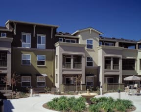 a large apartment building with a fountain in front of it
