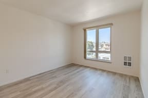 an empty room with wood floors and a window