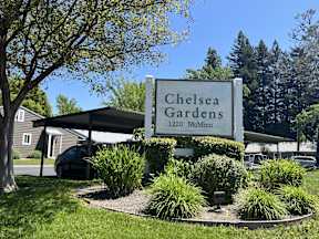 A sign for Chelsea Gardens stands in front of a building.