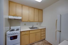 a kitchen with wood cabinets and a stove and a refrigerator