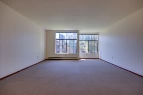 the living room of a home with a carpet and a window
