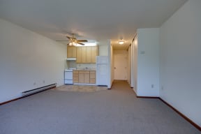 the living room and kitchen of an empty house with a ceiling fan