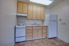 an empty kitchen with a stove refrigerator and sink