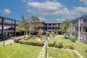 a view of the courtyard of a building with grass and trees