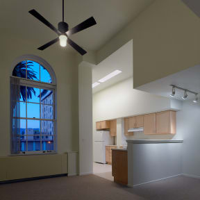 an empty kitchen with a large window and a ceiling fan