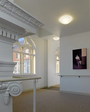 a large room with white pillars and windows and a tv on the wall