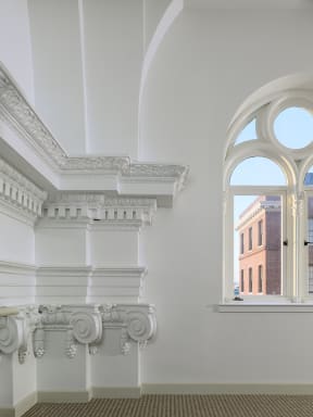 a view of a white room with a large window and a balcony