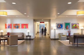 a lobby with couches and chairs and paintings on the wall
