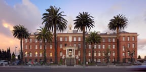 a large brick building with palm trees in front of it