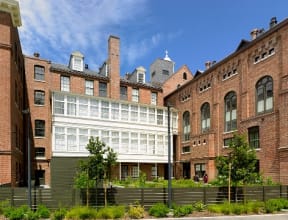 a view of the exterior of a building in front of some old buildings
