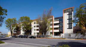 a row of apartment buildings on the side of a street