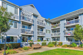 a building with multiple balconies and a bench in front of it