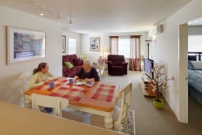 two people sitting at a dining table in a living room