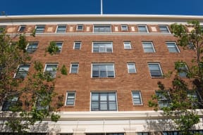 a red brick building with windows and a flag on top