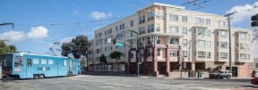 a city street with a blue bus and a building