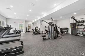 A gym with treadmills, weights, and exercise equipment.