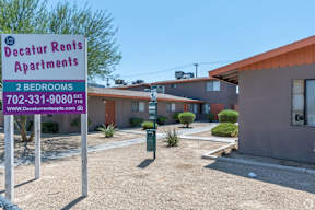 A sign for Decatur Rents Apartments with a phone number and website listed.