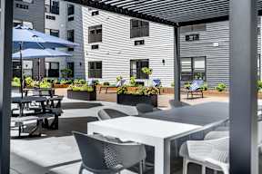 A patio with tables and chairs and umbrellas.