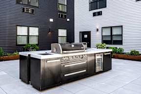 A modern outdoor kitchen with a built-in grill and sink.
