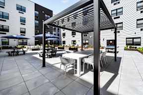 A patio with a table and chairs is surrounded by apartment buildings.