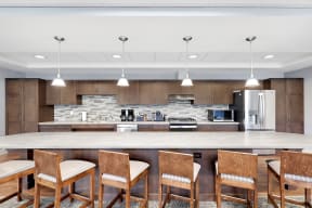 a kitchen with a large island with chairs and a counter