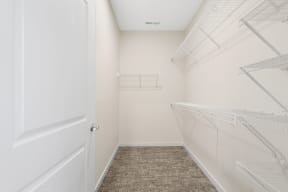 a spacious closet with white walls and white closets with white doors