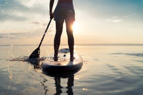 a person standing on a paddle board in the water