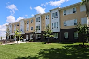 Apartment building with a grassy area in front.