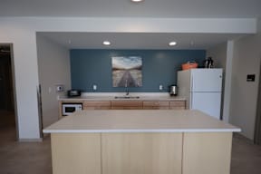 A kitchen with a white counter top and wooden cabinets.
