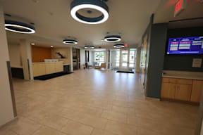A hallway with a light on the ceiling and a sign on the wall.
