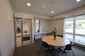 A conference room with a table, chairs, and a large window.