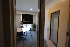 A conference room with a sign that says "161 Meeting".