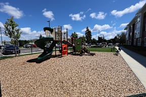 A playground with a green slide and orange structure.