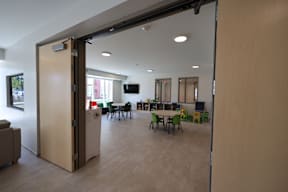 A room with a table and chairs is visible through a sliding door.