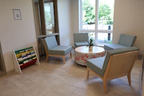 A room with a table and chairs and a plant on the table.
