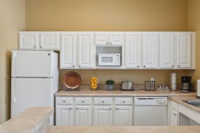 a kitchen with white cabinets and a white refrigerator