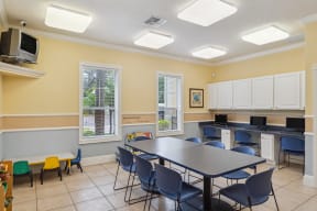 a classroom with a long table and chairs