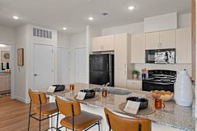 A kitchen with a table and chairs.