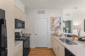 A kitchen with a black fridge and black oven.