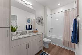 A bathroom with a toilet, sink, and shower.