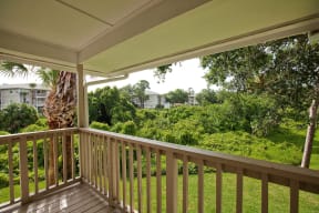 a balcony with a view of a yard and trees