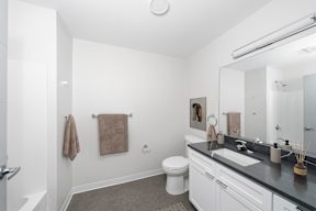 A bathroom with a toilet, sink, and towel.