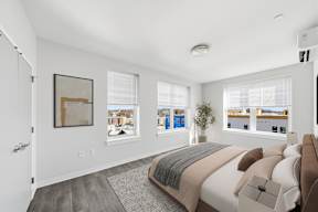 A bedroom with a large bed and a view of the city.